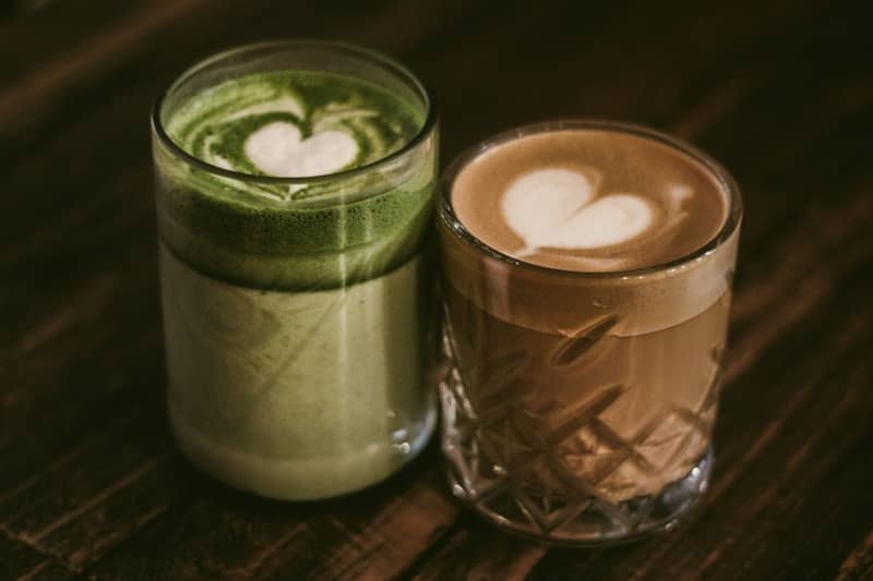 Two latte drinks with heart-shaped foam.