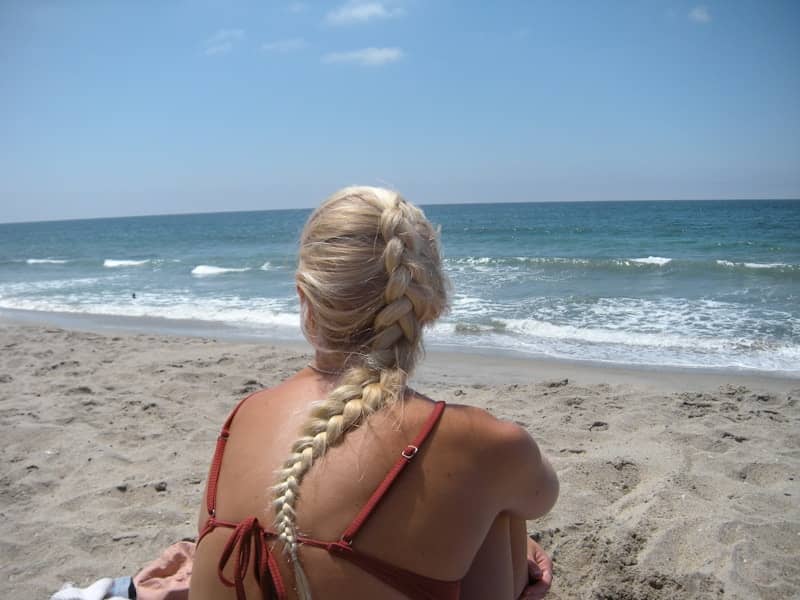 Woman with braided blonde hair on sandy beach
