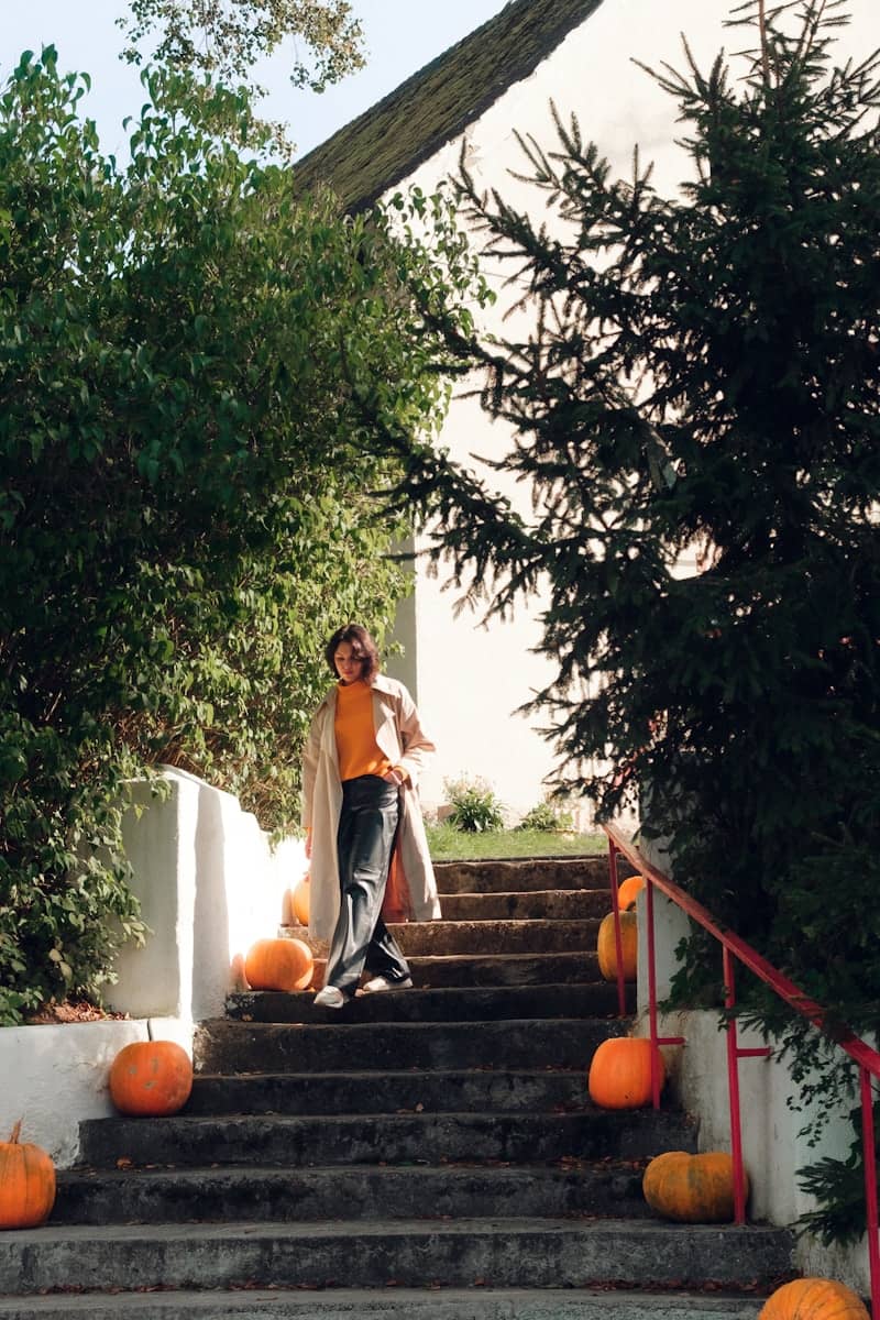 Woman on stairs with pumpkins during autumn