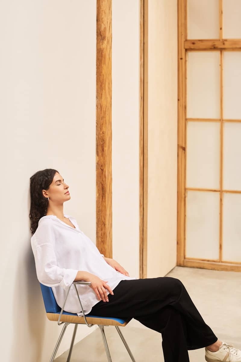 Woman sits relaxed with her eyes closed 