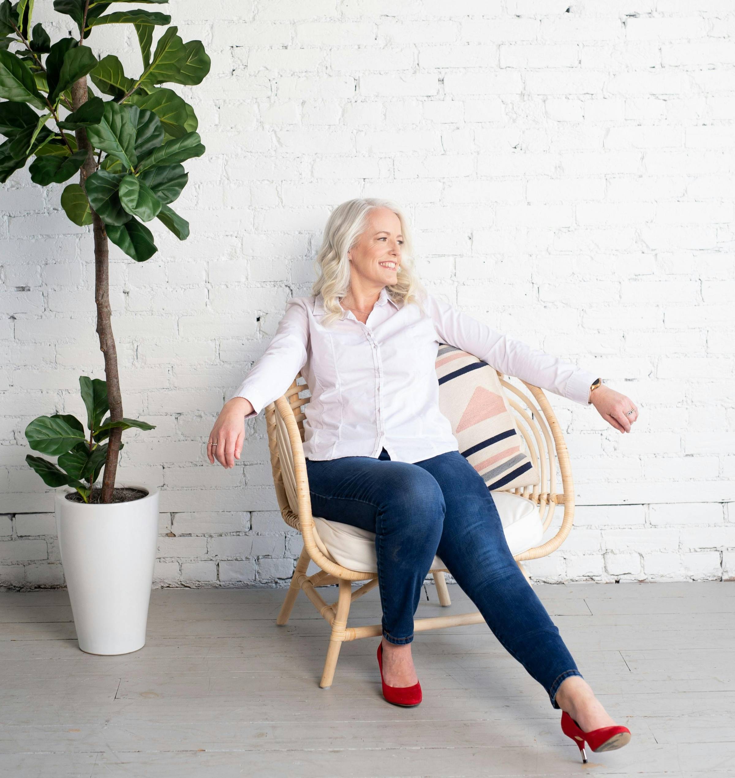 woman sitting on floor and leaning on couch using laptop