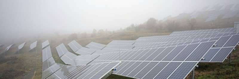 Solar panel field shrouded in thick morning fog