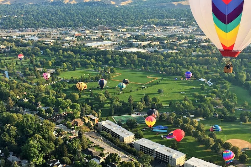 aerial view of green grass field with hot air balloons