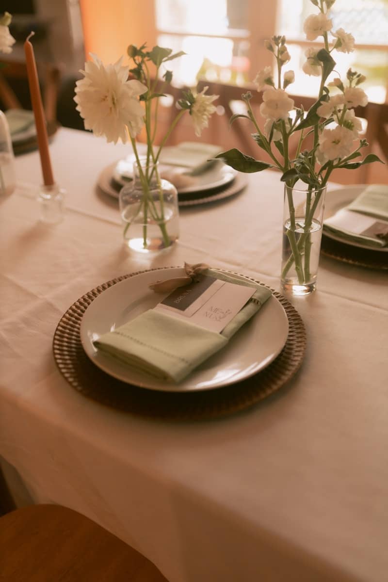 Elegant table setting with white flowers and napkins.