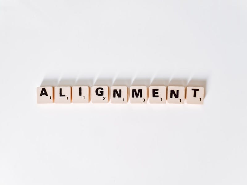 the word alignmentment spelled with scrabble letters