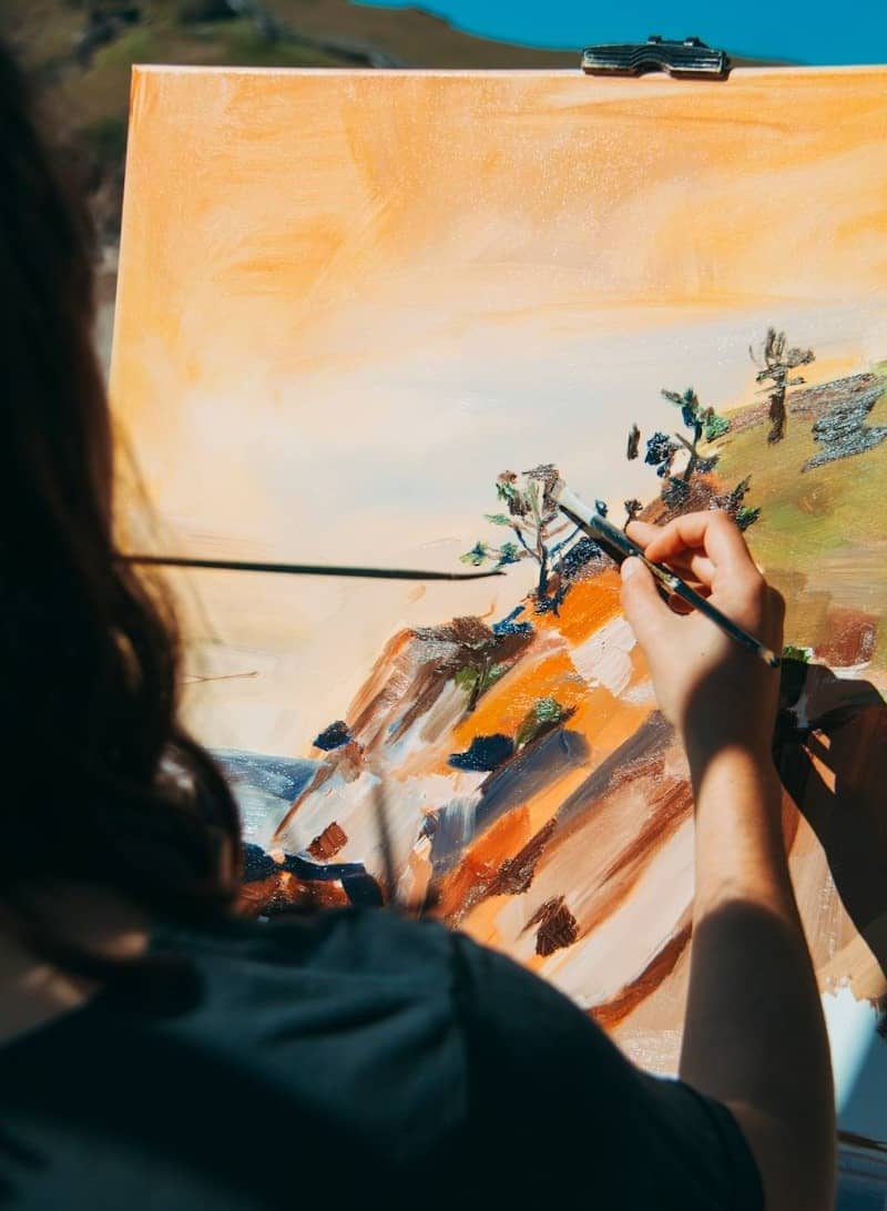 woman painting tree and cliff