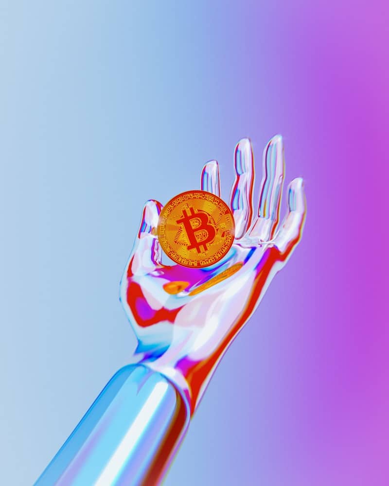 A hand holding a bitcoin in it's palm