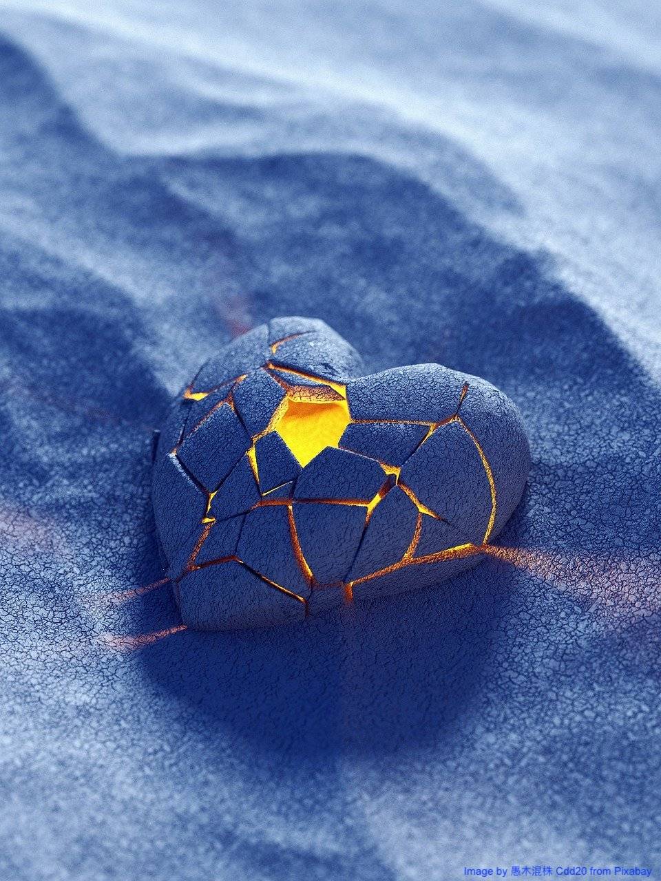 A blue-purple clay heart, put together again in pieces, with a golden light glowing from within.