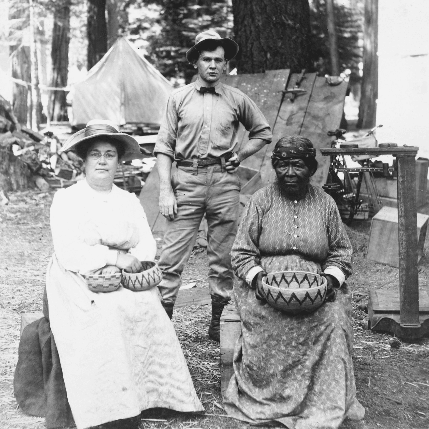 two women sit on chairs and hold baskets in their laps
