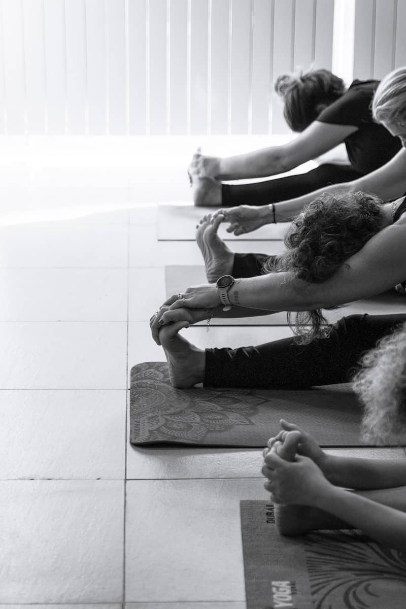 People stretching on yoga mats in a studio.