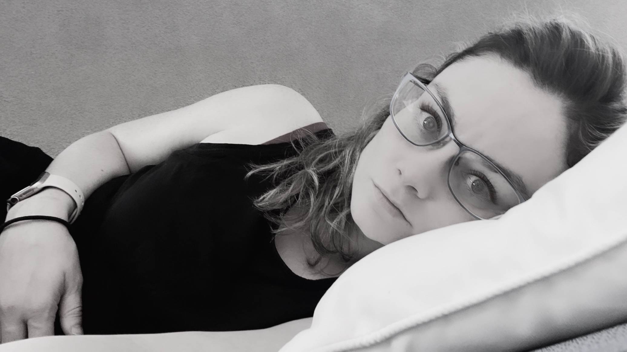 A photo I took in the aftermath of Will's SCA. You can see how I had dissociated – the light was gone from my eyes. It's black and white, and I'm laying on my side as I look directly at the camera.