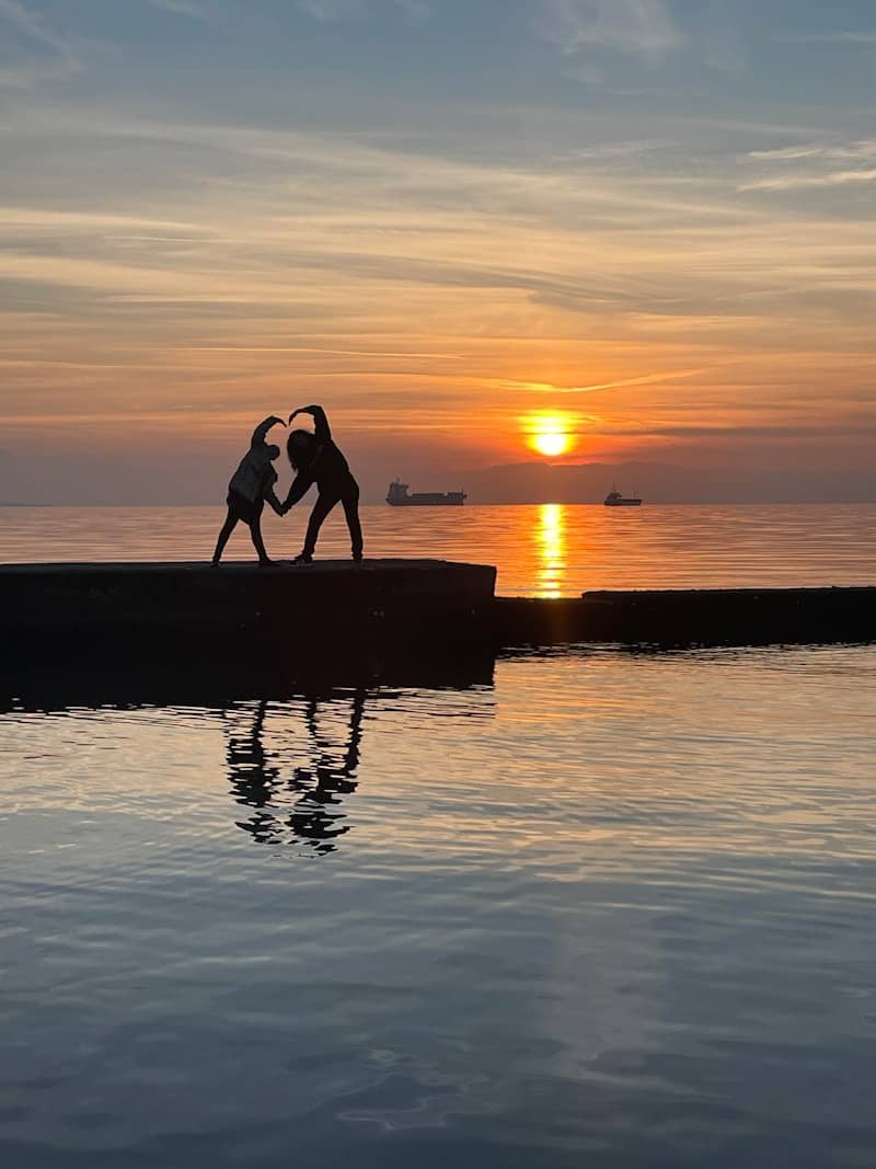 A couple of people that are standing in the water