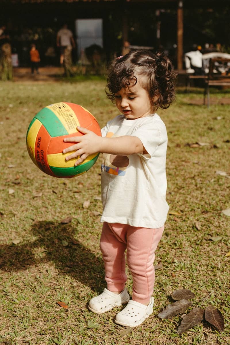 A child holds a colorful ball.