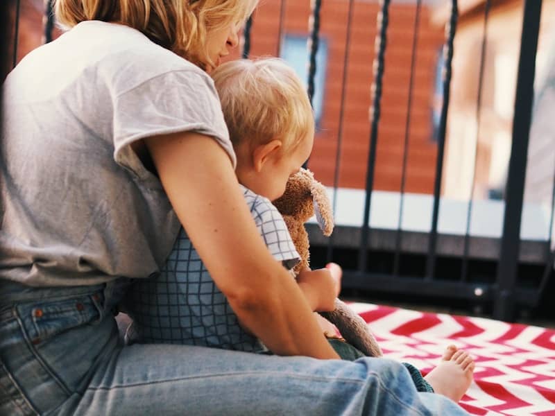 A woman sitting on the ground holding a baby