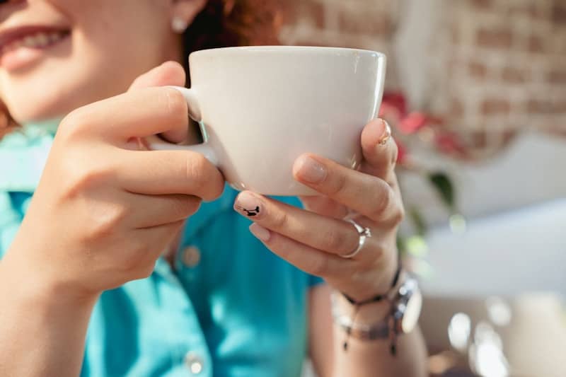 A woman holding a cup of coffee in her hands