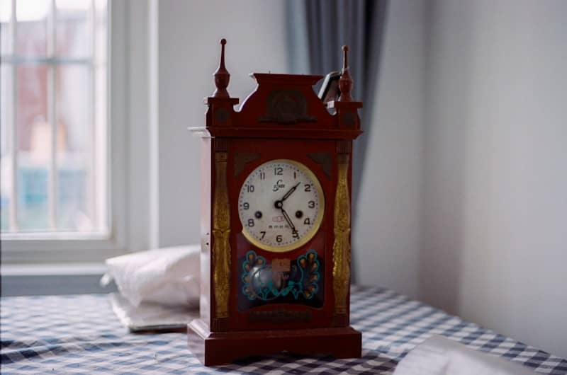 A wooden clock sitting on top of a checkered table cloth