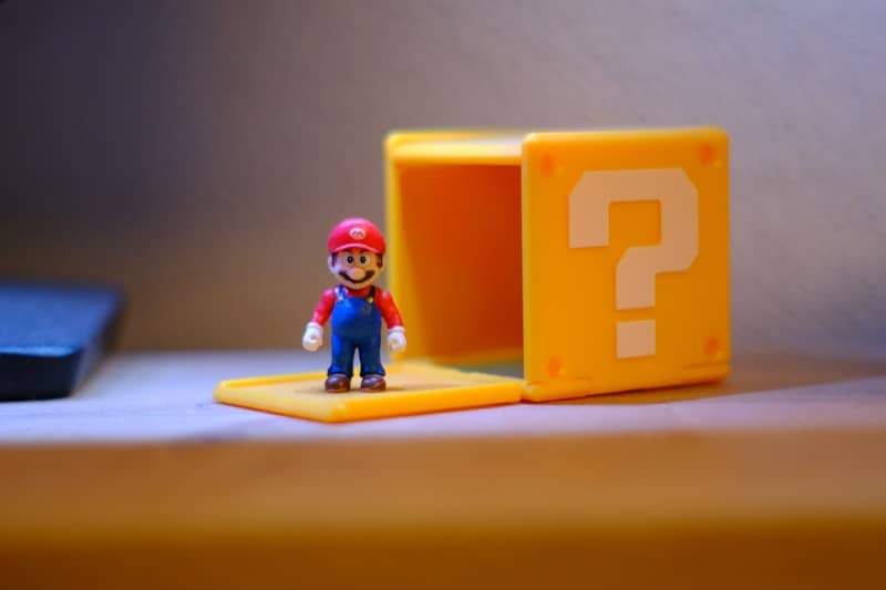Mario figurine beside an open yellow question mark block.