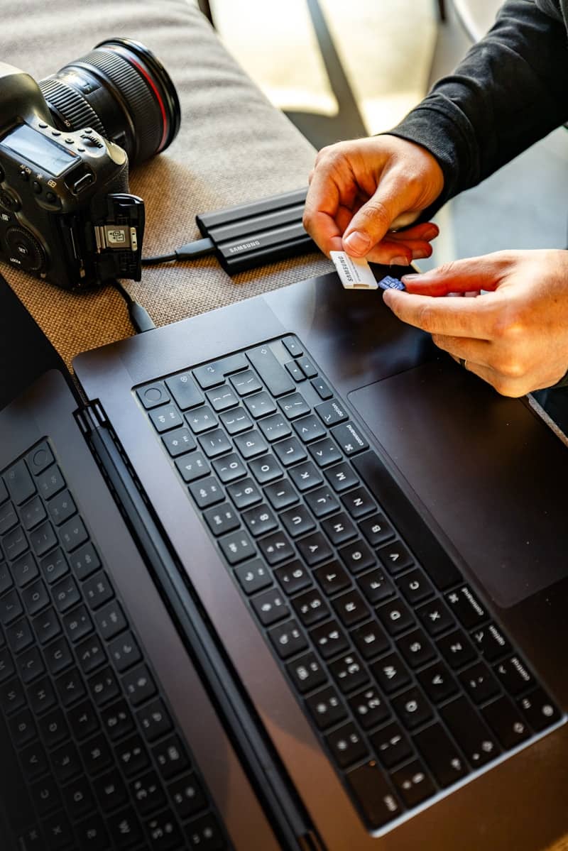Hands inserting sd card into laptop reader