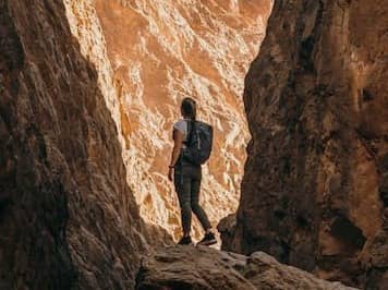 a person standing on a rock in a canyon