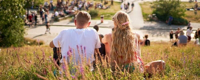 a couple of people that are sitting in the grass