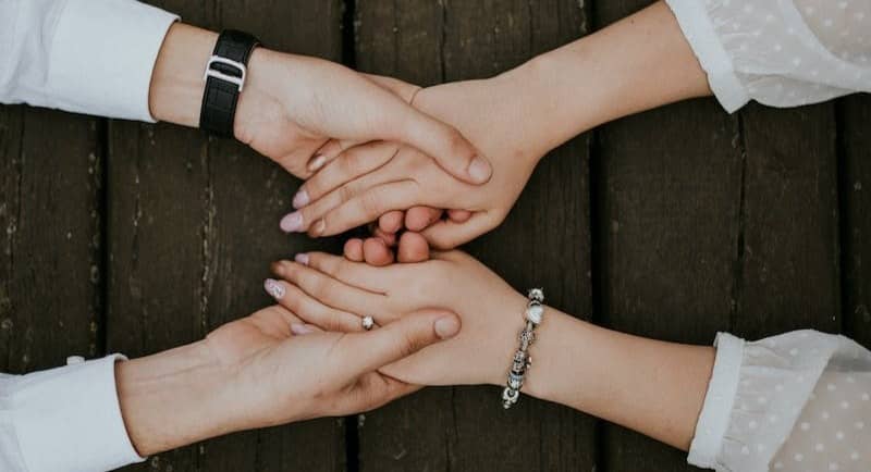 flat lay photography of man and woman holding hands together