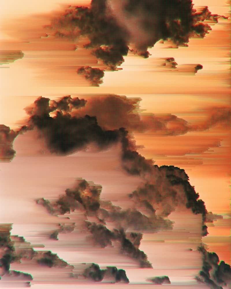 Dark clouds against a warm orange sky with horizontal digital glitch distortion