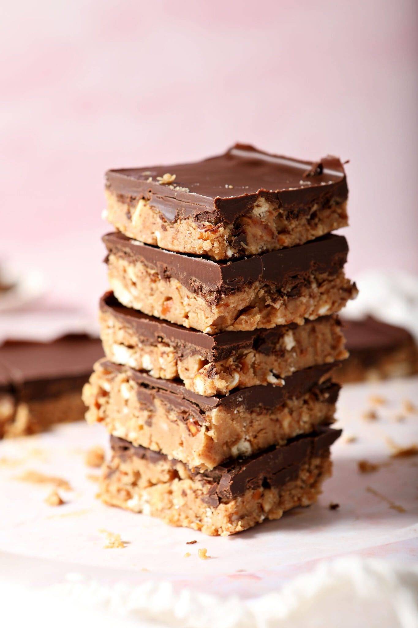 a stack of no bake peanut butter bars coated in chocolate stacked on top of each other