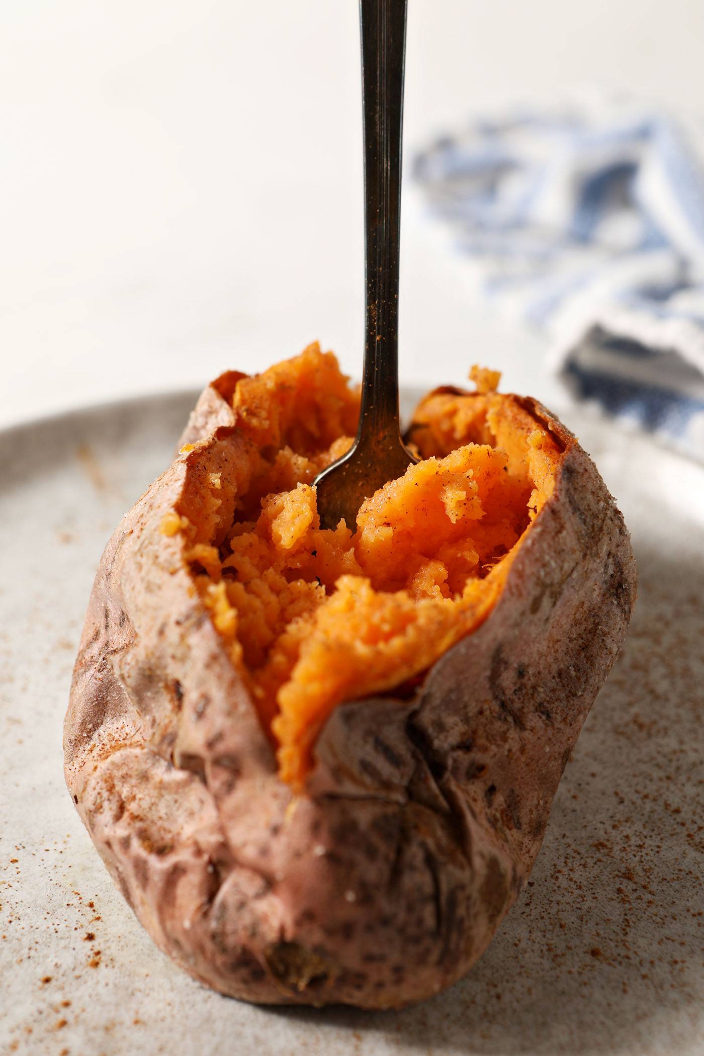 a halved sweet potato with a fork inside it