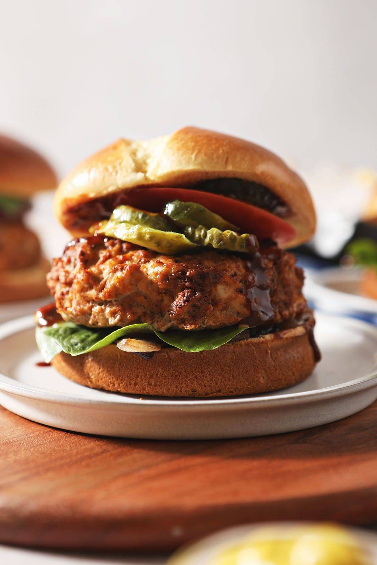 A barbecue turkey burger dressed with toppings on a plate 
