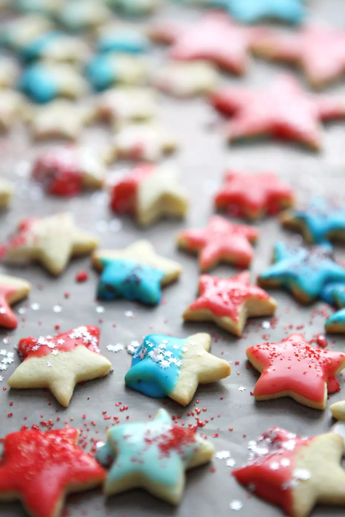 red, white and blue sugar cookies on a dark countertop