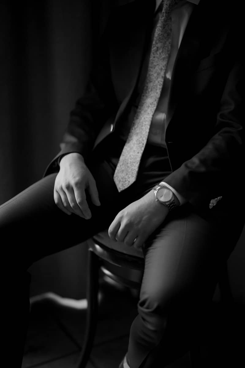 A man in a suit sits on a chair.