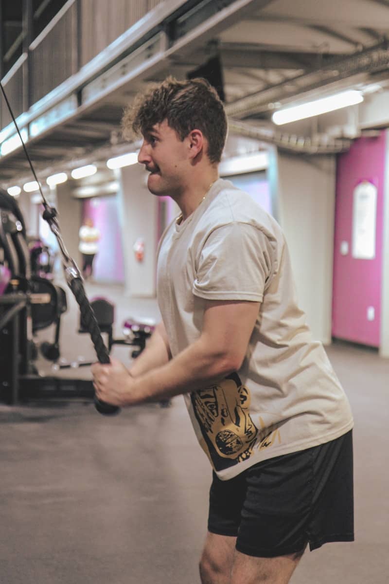 a man holding a pole in a gym