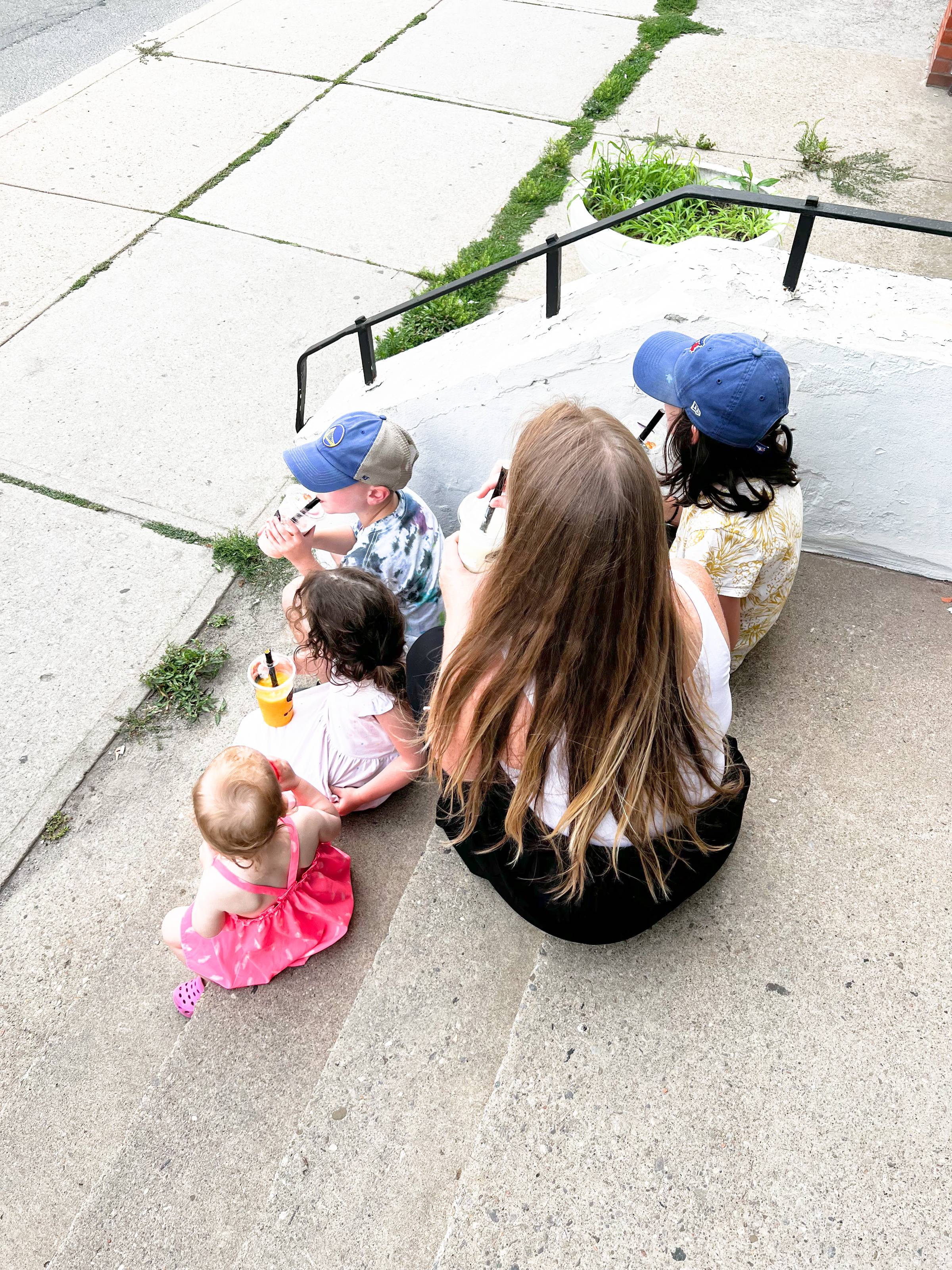 Image of Rebecca Joy of joybeforework.com sitting on outdoor steps with her four children, ages 2-9
