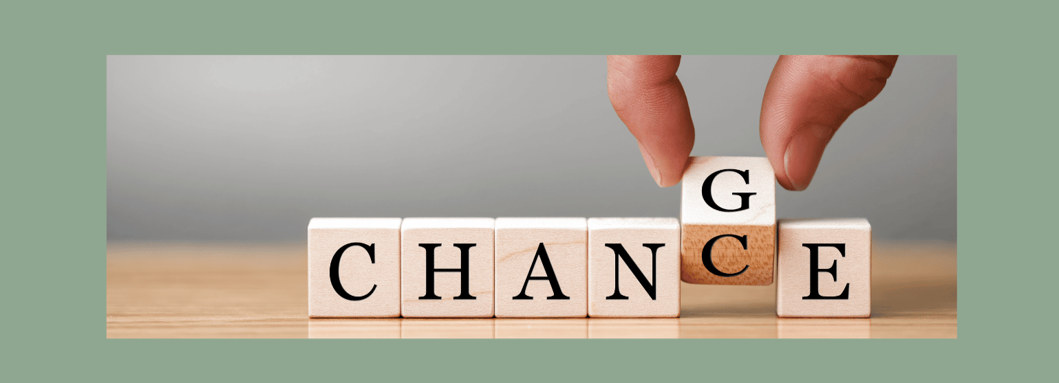 “A hand gently shifts a wooden block from ‘chance’ to ‘change,’ capturing the quiet moment where possibility becomes transformation.”