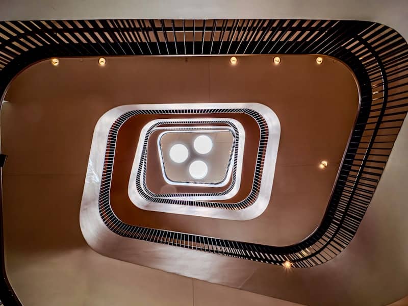 Looking down a modern spiral staircase with lights