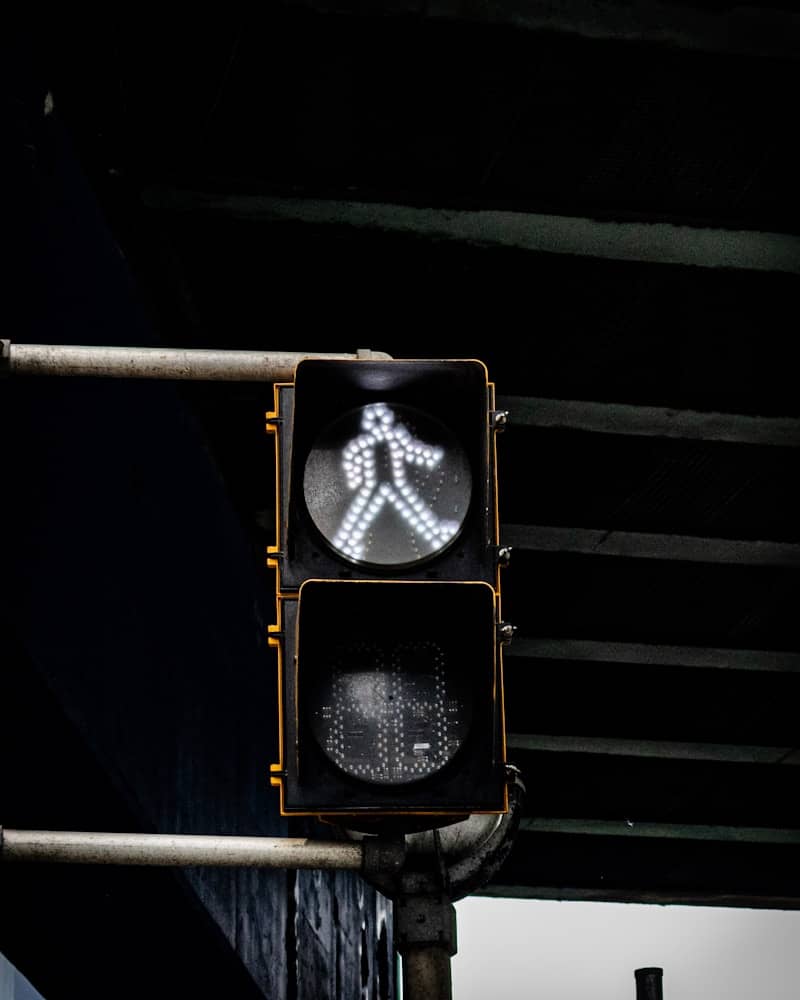 A pedestrian signal shows a white walking figure.