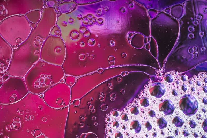 A close up picture of water droplets on a purple background