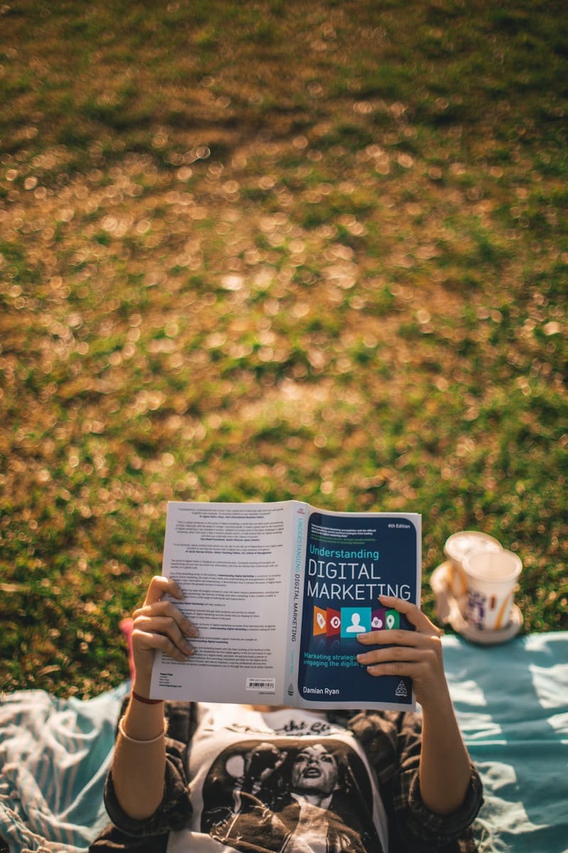 person reading book about digital marketing outside