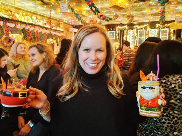 I'm at a holiday bar holding 2 tiki santa drinks