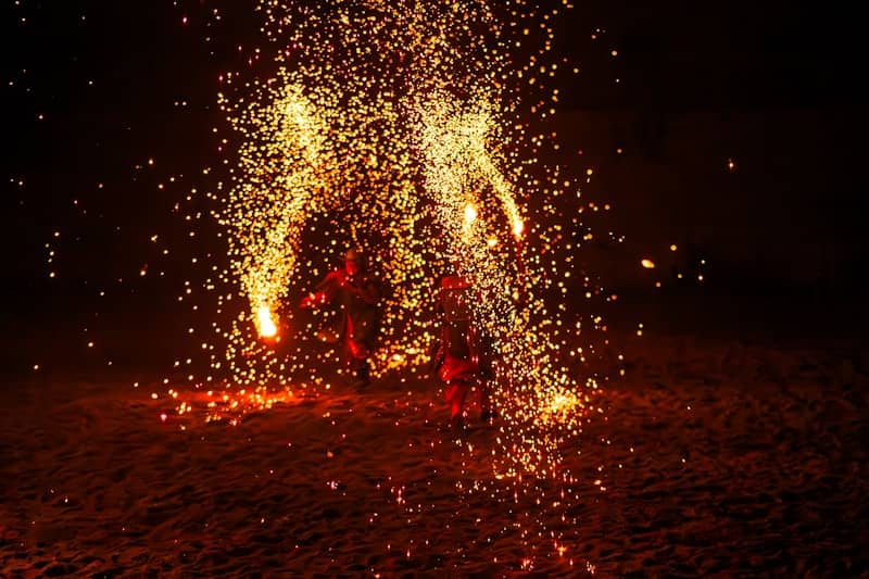 Sparks fly from a fire at night