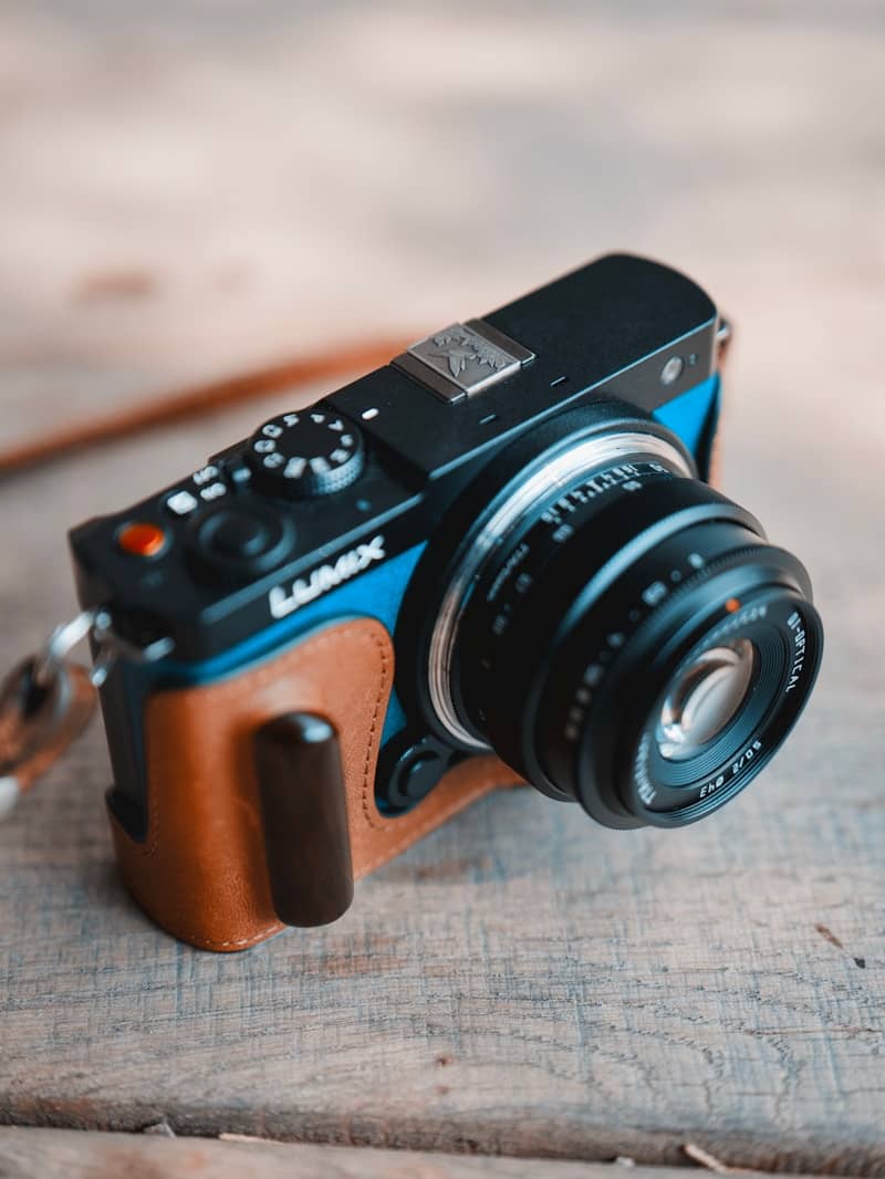 A digital camera rests on a wooden surface.