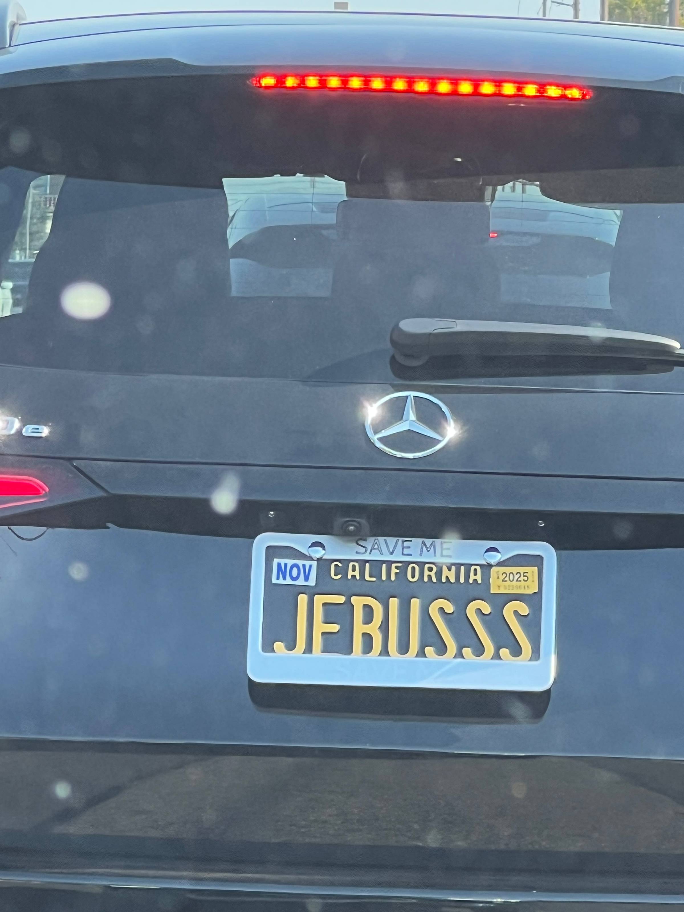license plate of car reading "JEBUSSS" the frame reads "SAVE ME"
