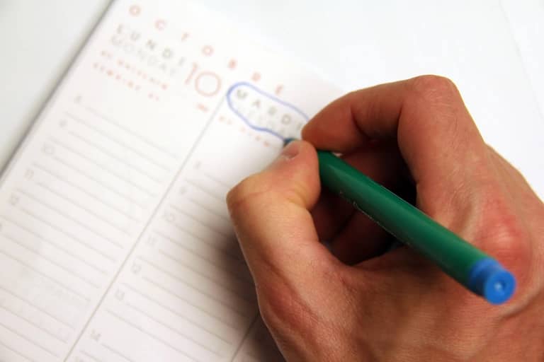 A small business owner planning the week with a calendar and notebook