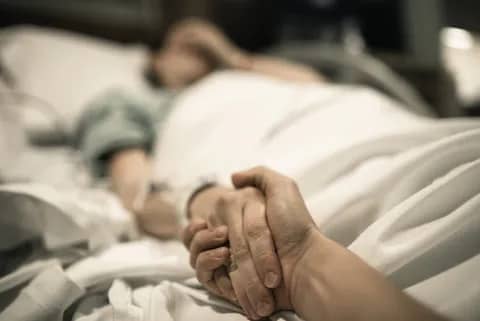 holding a person's hand while visiting in the hospital
