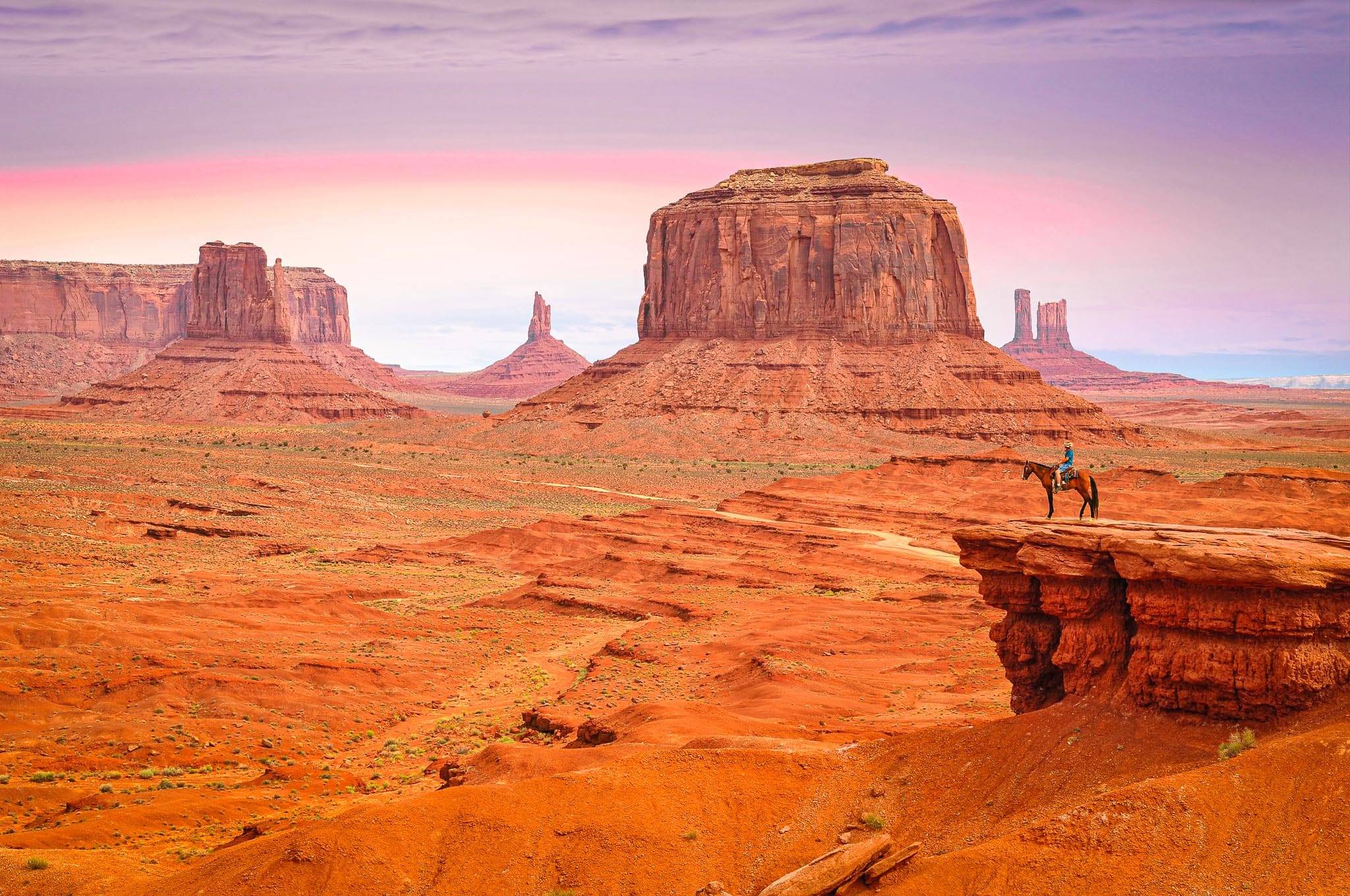 A lone rider on horseback at John Ford’s Point in Monument Valley, gazing over West Mitten Butte and Merrick Butte on the Utah-Arizona border.