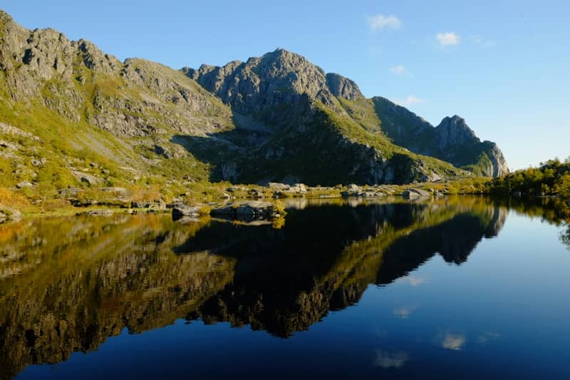 Rocky mountains reflected in a calm, dark lake