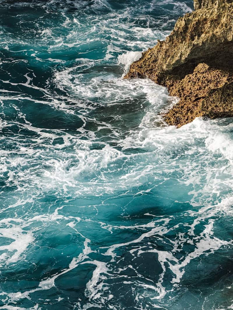 Waves crash against a rocky coastline.