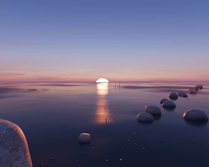Sunset over a calm ocean with stepping stones
