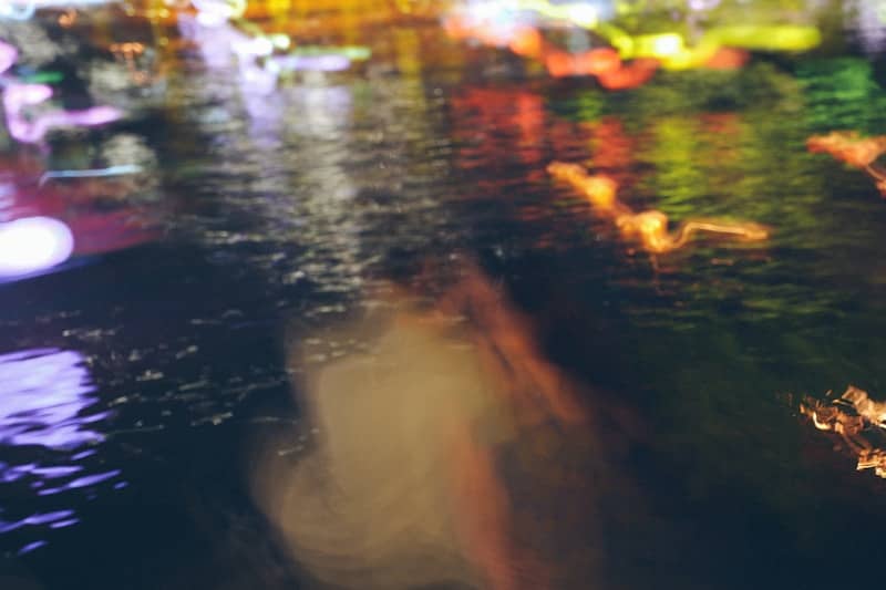 Blurry reflections of colorful lights on dark water