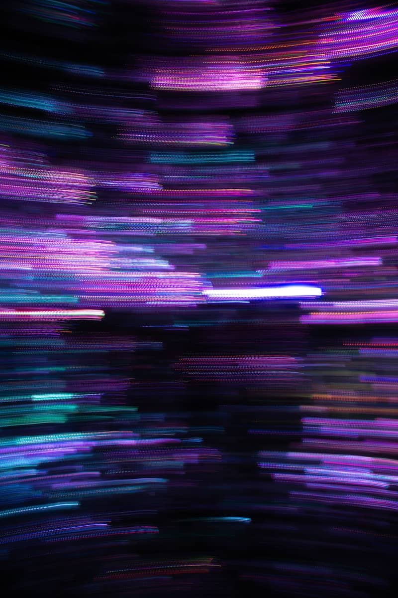Horizontal streaks of neon purple and blue light against a dark background